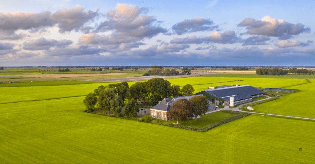 Lush green fields with farm buildings.